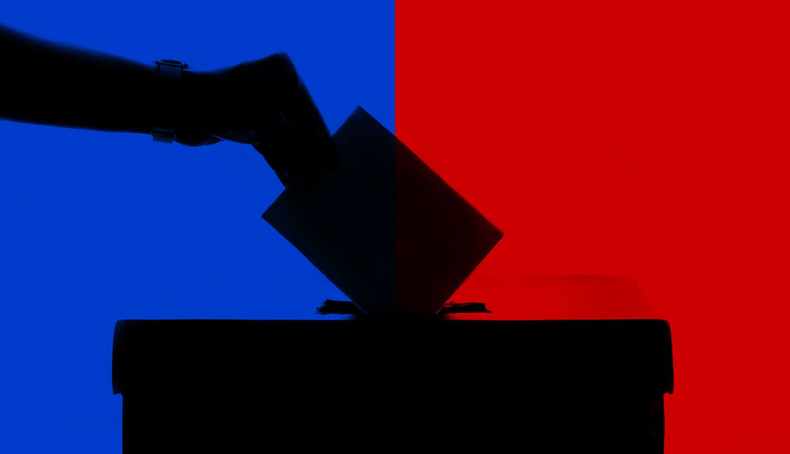 A hand dropping a ballot into a ballot box, in front of a split background of blue and red